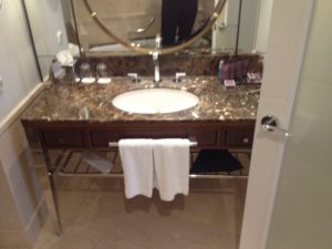 a bathroom sink with a round mirror