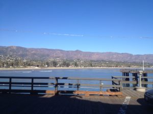 a pier with a body of water and mountains in the background