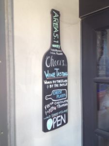 a chalkboard with a wine bottle on the wall