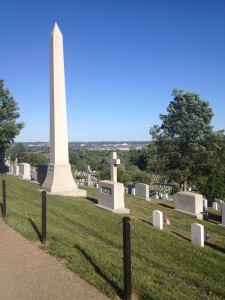 a tall white obelisk in a cemetery
