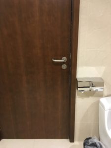 a brown door next to a toilet