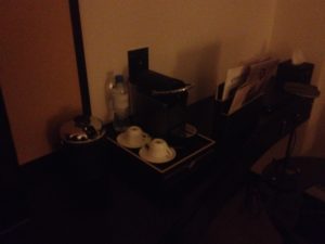 a coffee maker and cups on a table
