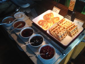 a tray of waffles and jams on a table