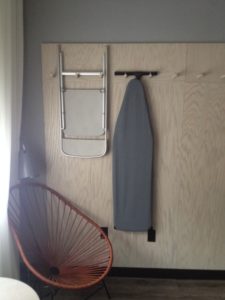 a chair and ironing board on a wall