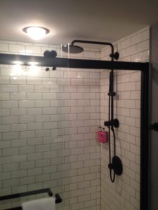 a shower with a black shower head