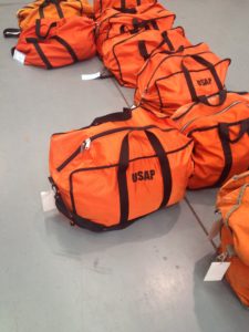 several orange duffel bags
