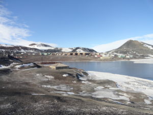 a snowy landscape with a lake and buildings